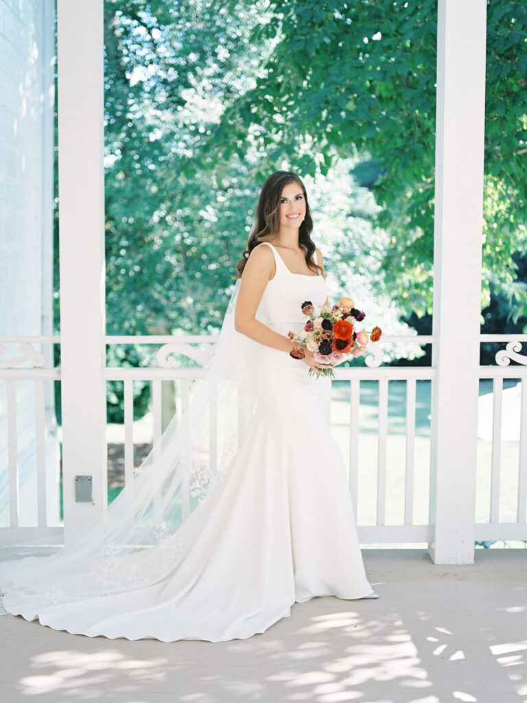 Bride in traditional sheath wedding gown and holding boquet of flowers