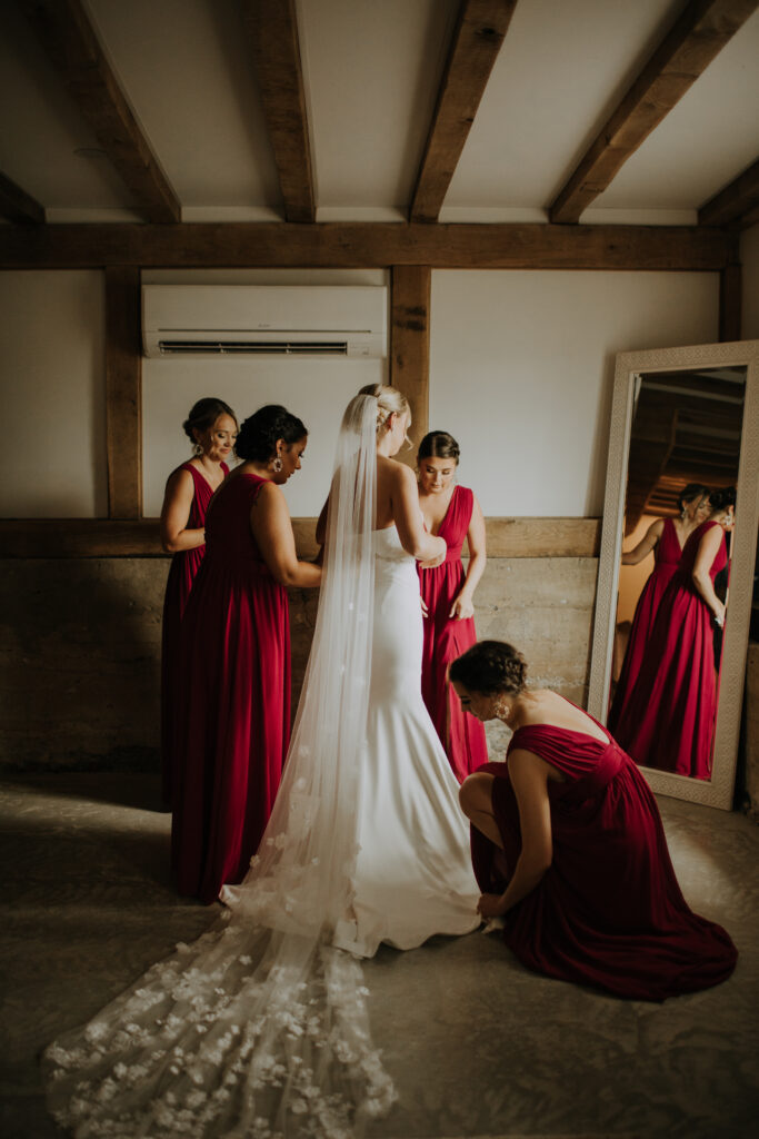 four bridesmaids help bride get ready