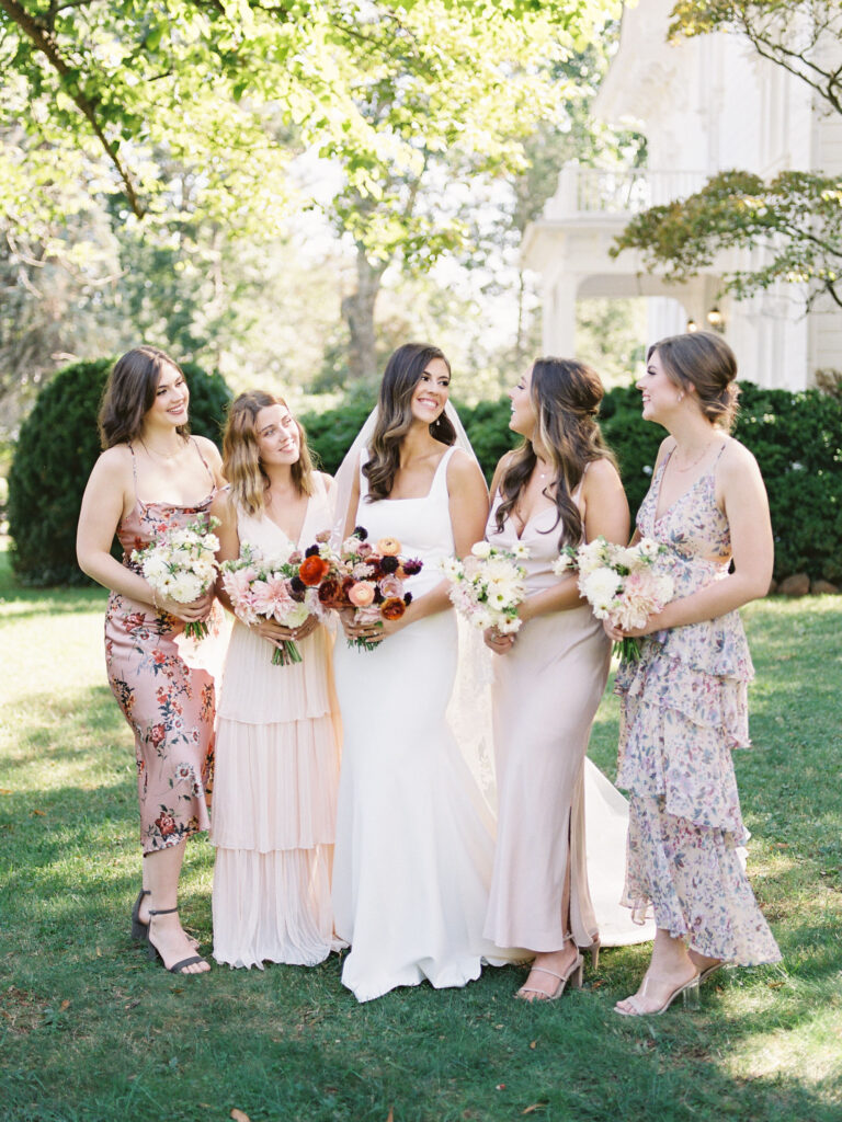 bride and 4 bridesmaids in formal wear earch holding bouquets of flowers
