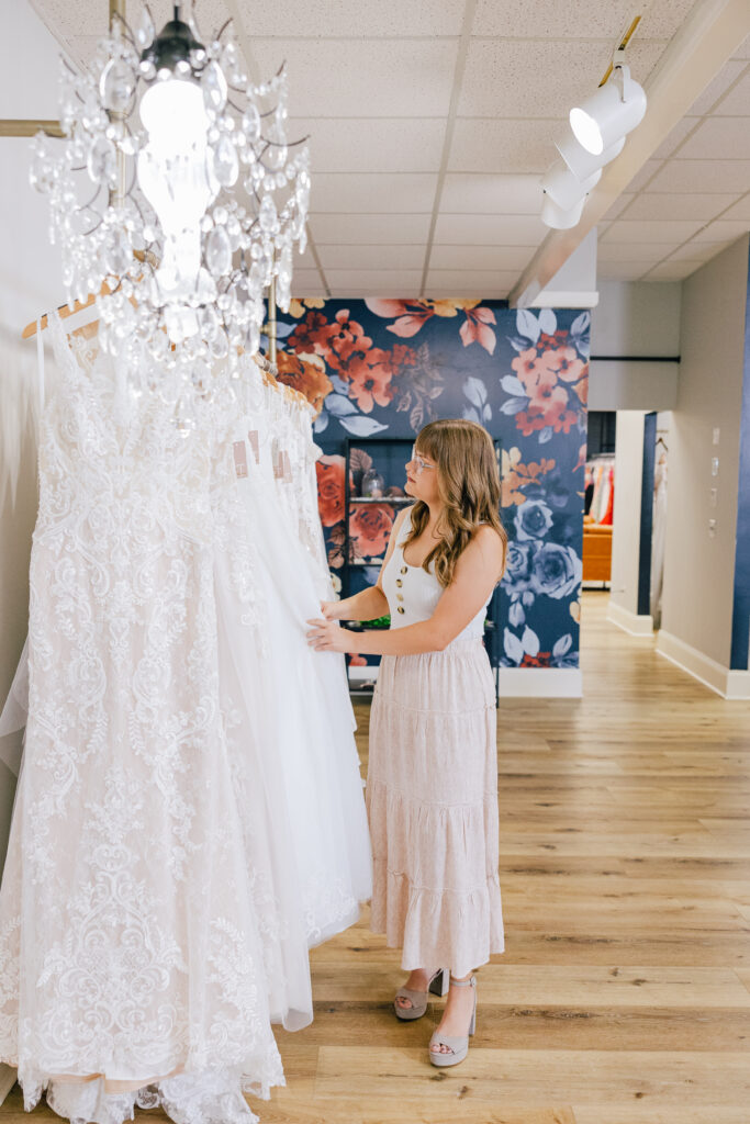 bride shopping for white, lacey bridal gowns