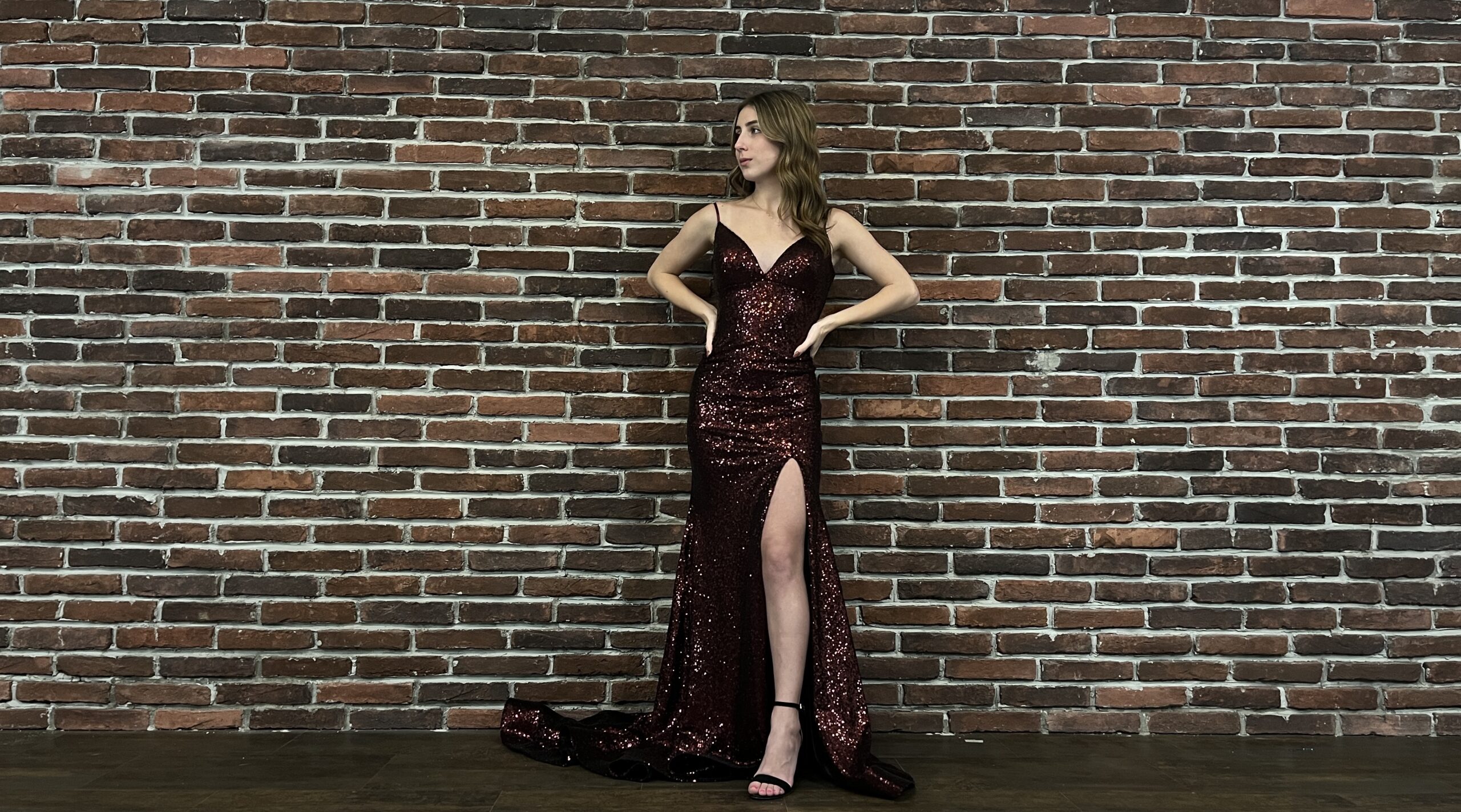 young woman in sparkly prom/pageaent dress with leg slit