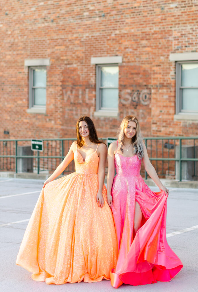 two women in colorful prom or pageant gowns