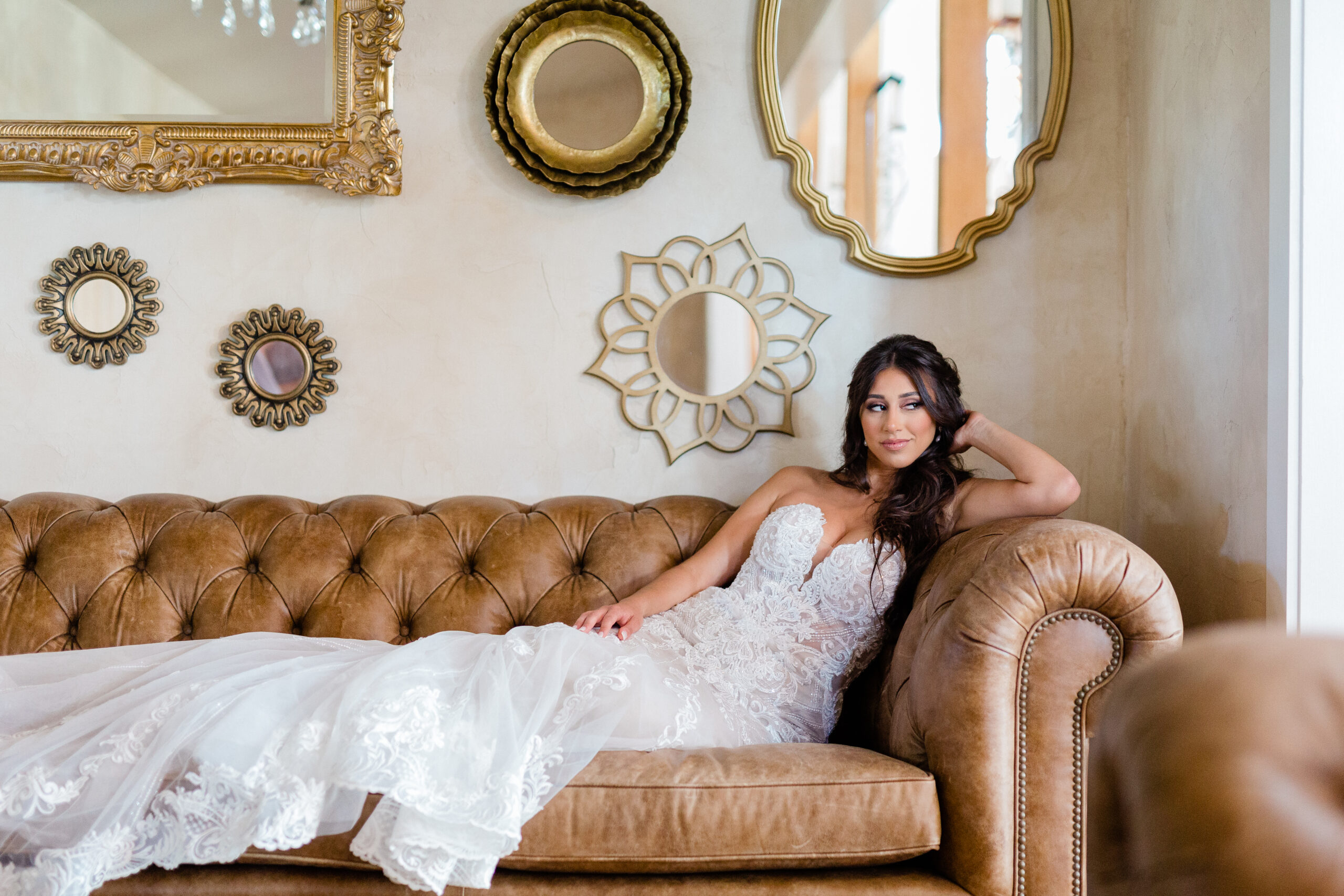 bride in bridal gown laying on couch and looking off camera