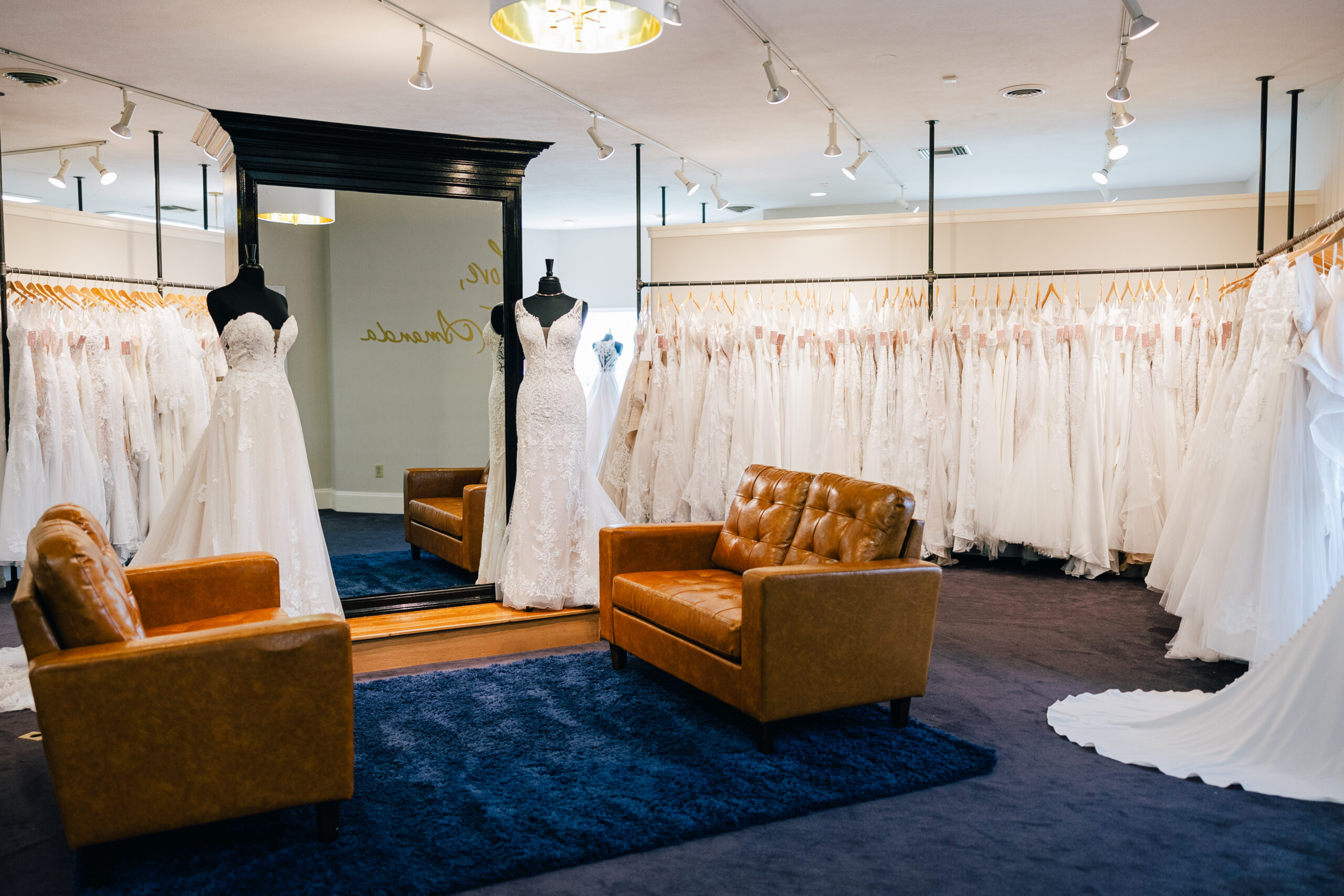 seating area surrounded by racks of bridal gowns