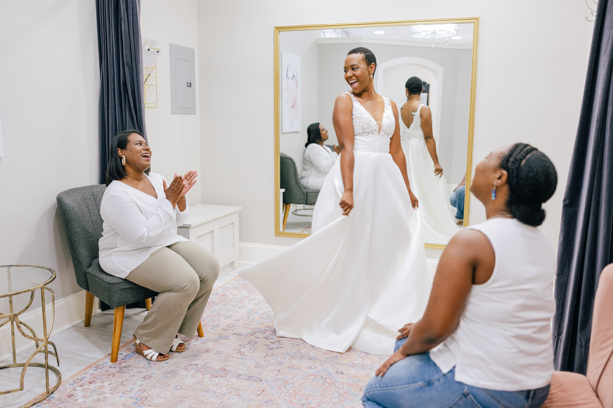 bride trying on white bridal gown while close loved ones cheer