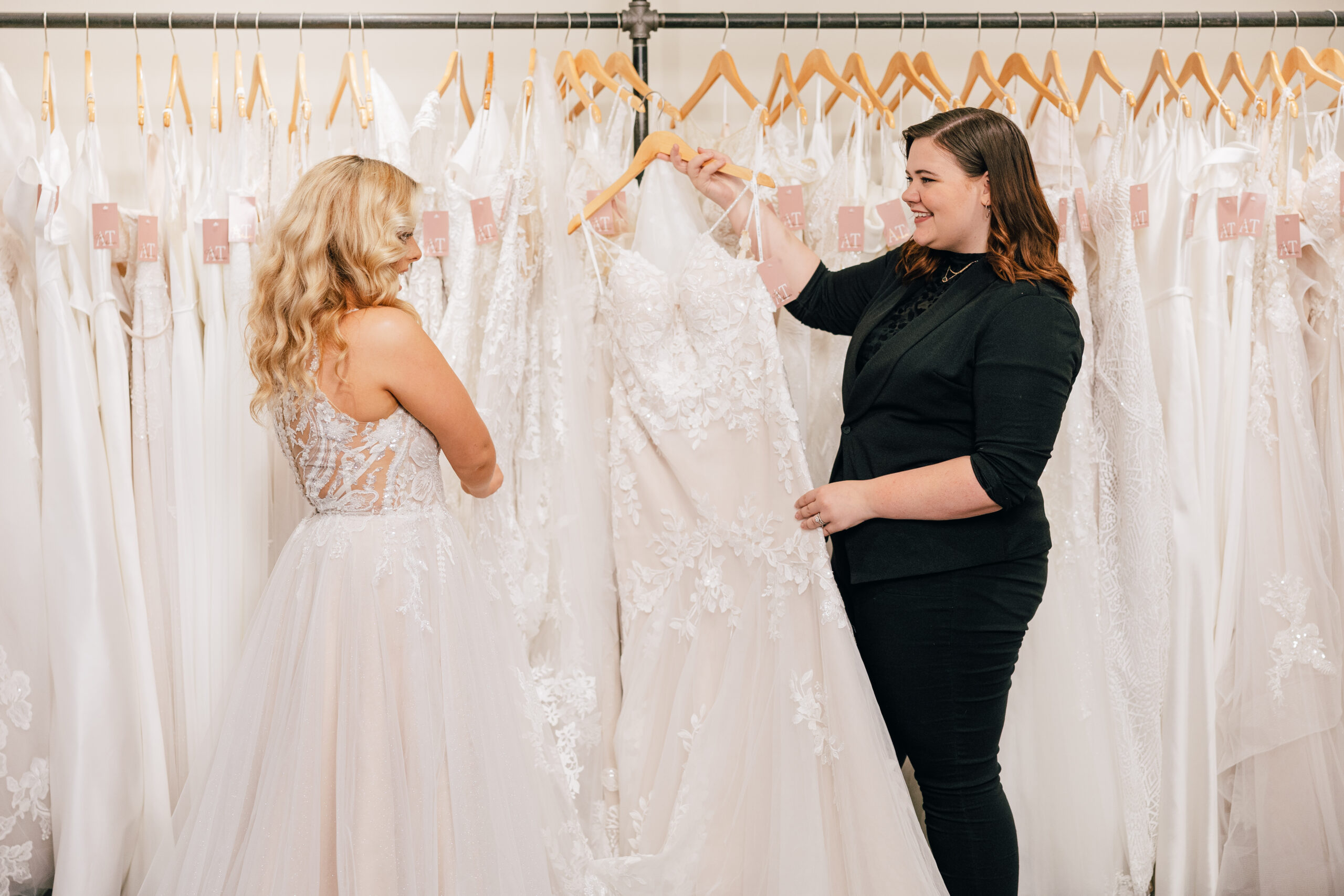 stylist showing bride a fit and flare style wedding gown