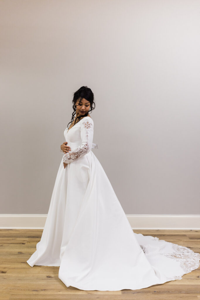 bride posing in simple, elegant long sleeve wedding dress