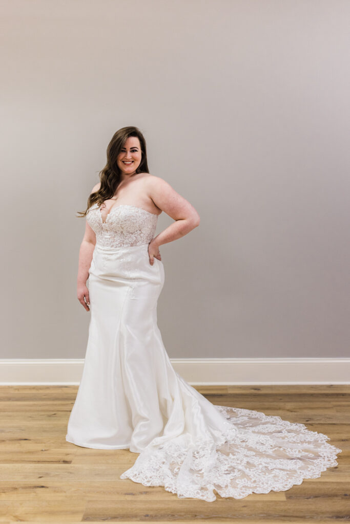 plus size bride smiling and posing in a simple fitted wedding dress