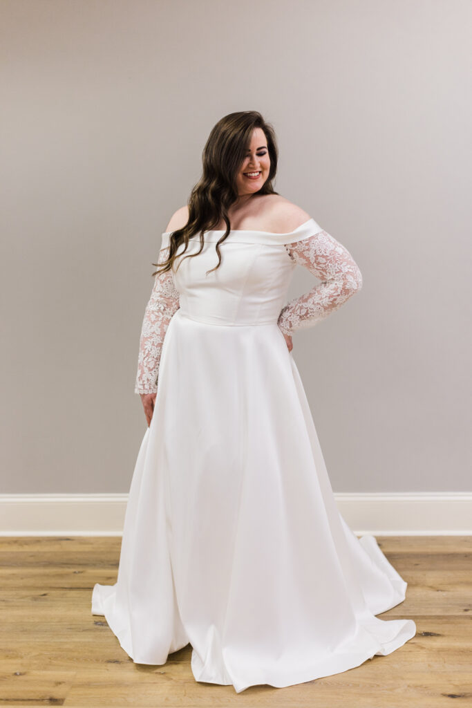 plus size bride posing in simple and elegant long sleeve wedding gown