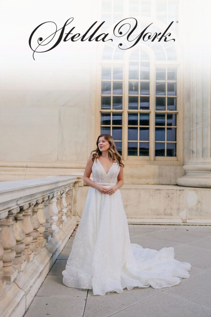 bride standing outside in a wedding dress with Stella York logo at the top 