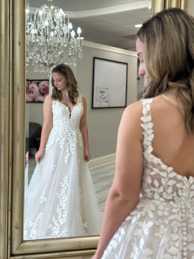 Woman wearing an a-line wedding dress and looking at the silhouette in the mirror