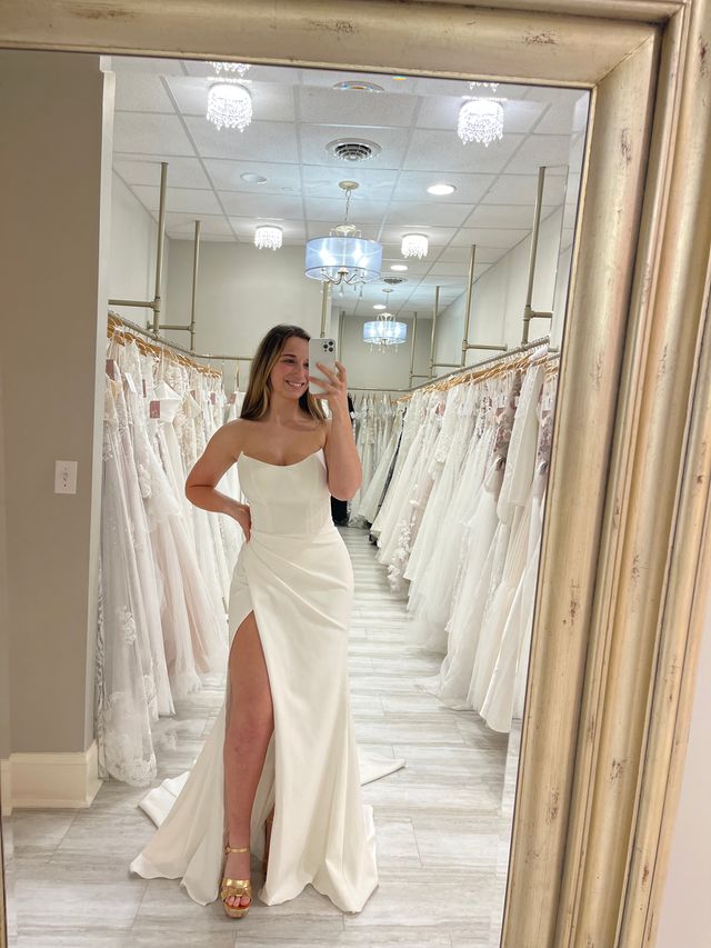 Bride taking a selfie in the mirror of her new sheath wedding gown at Amanda's Touch