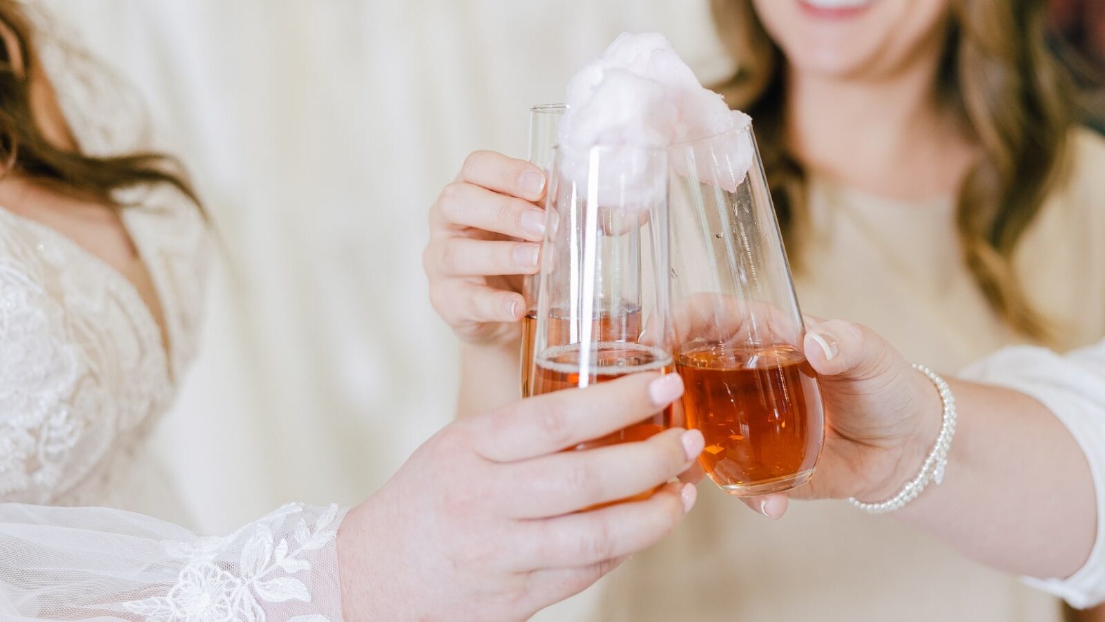 multiple women clinking glasses together as a bride finds her dream wedding dress at Amanda's Touch