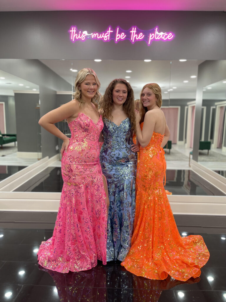 Three young girls wearing pink, blue, and orange prom dresses at Amanda's Touch in Virginia