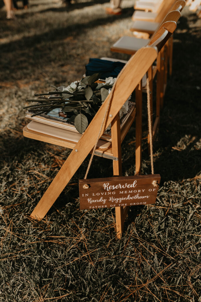 Reserved memorial seat with a sign in loving memory at a wedding ceremony.