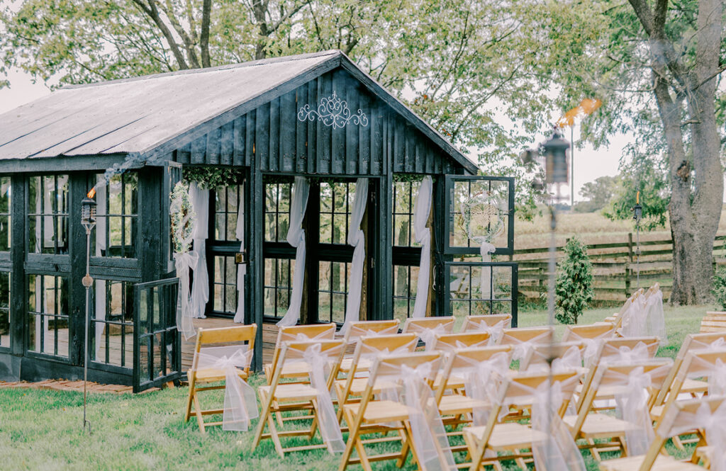 Old barn turned into a wedding venue, adorned with white drapes and set against a rural backdrop.