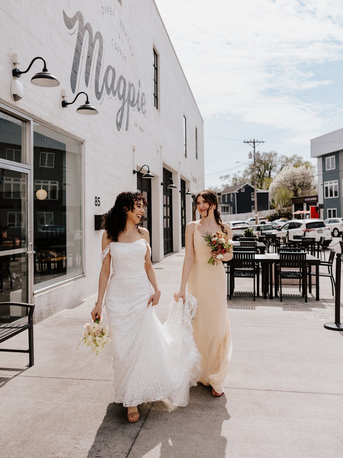 Amanda's Touch bride to be wearing her wedding dress and walking with her bridesmaid.