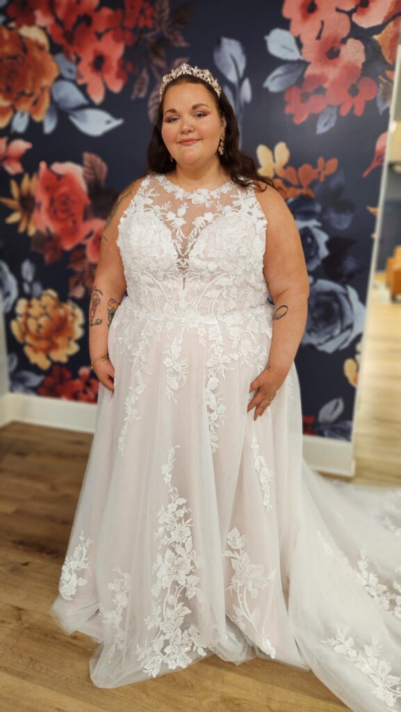 A bride is dressed in an elegant lace wedding gown, complemented by a coordinating tiara.